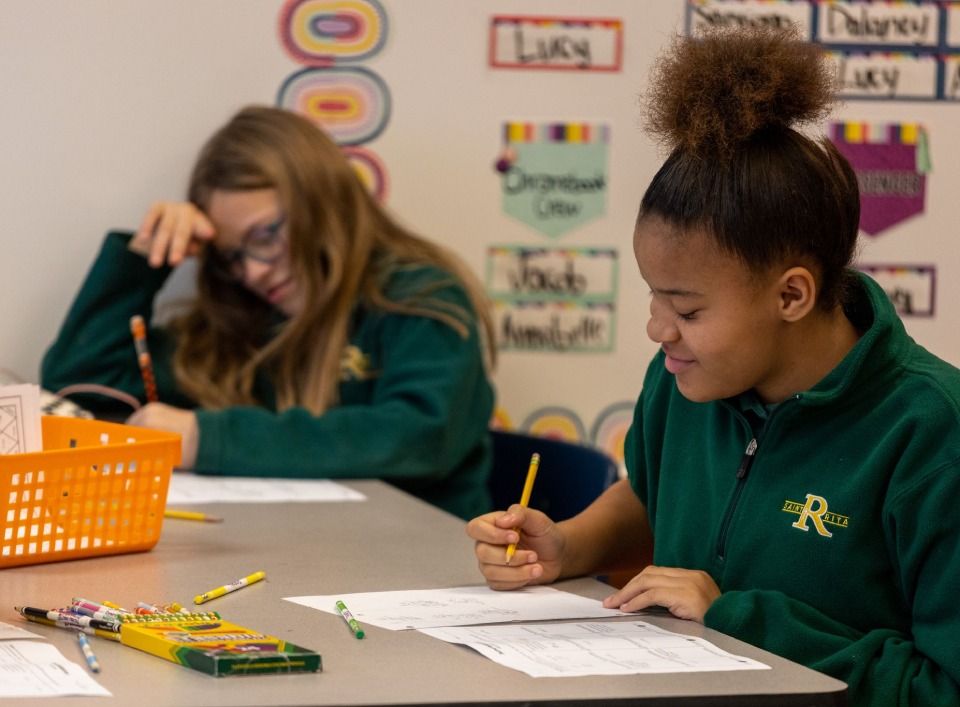 Two students sitting at table solving math worksheets