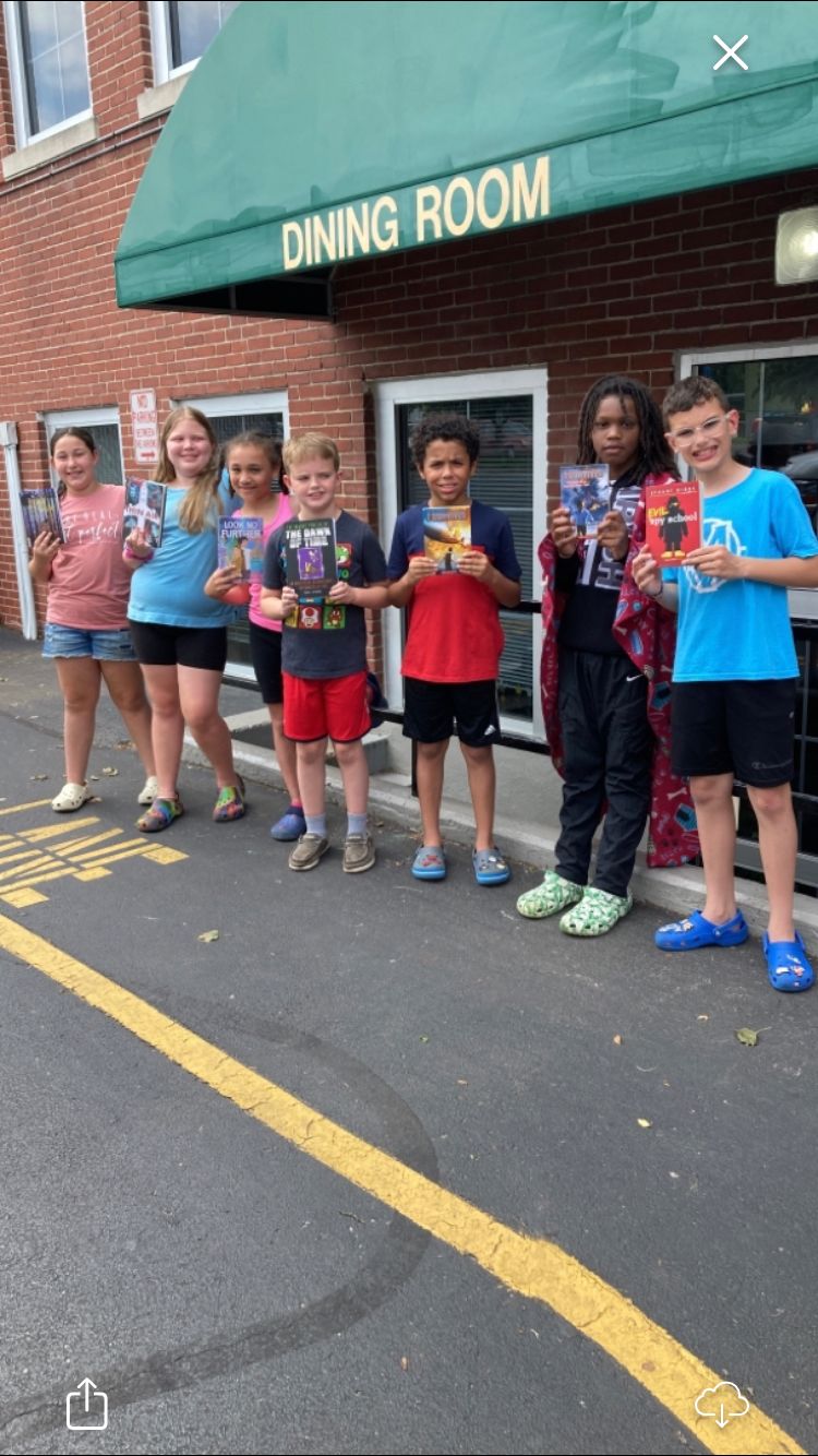 Children displaying library books checked-out