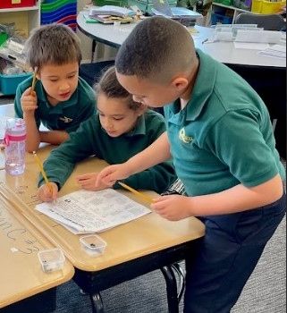 Three students working together one a worksheet