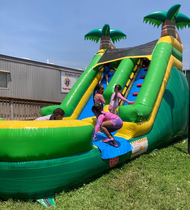 Students playing on an inflatable slide