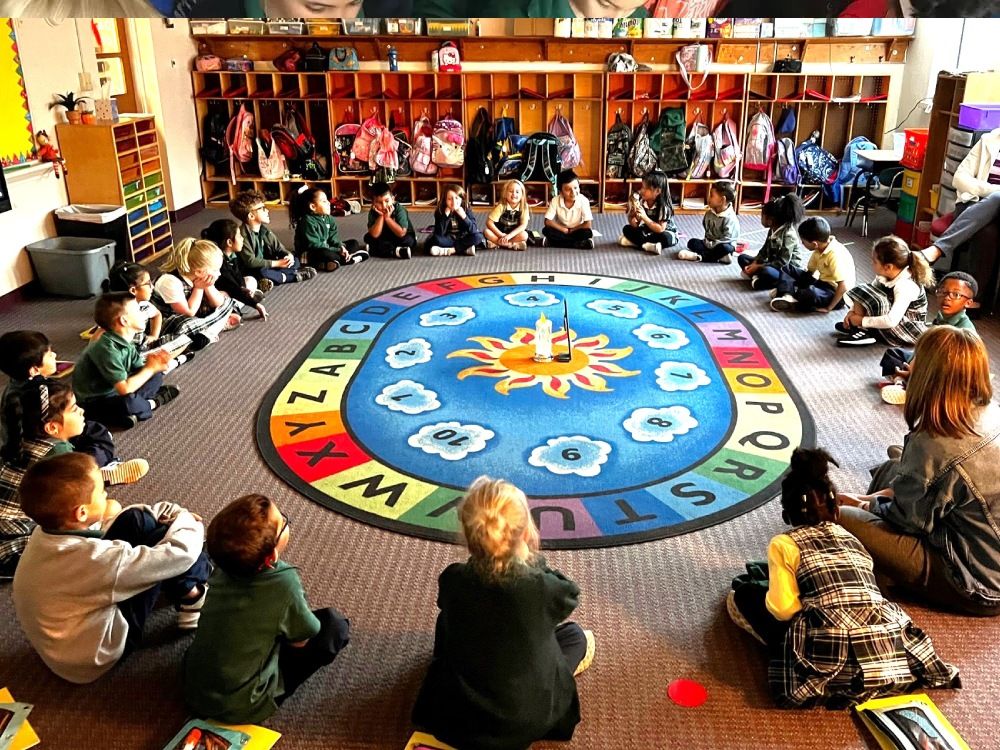 Students sitting with teacher in group session of virtue based restorative discipline