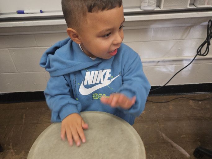Child playing the drums in music class