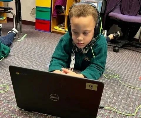 Student working on Chromebook with headphones on