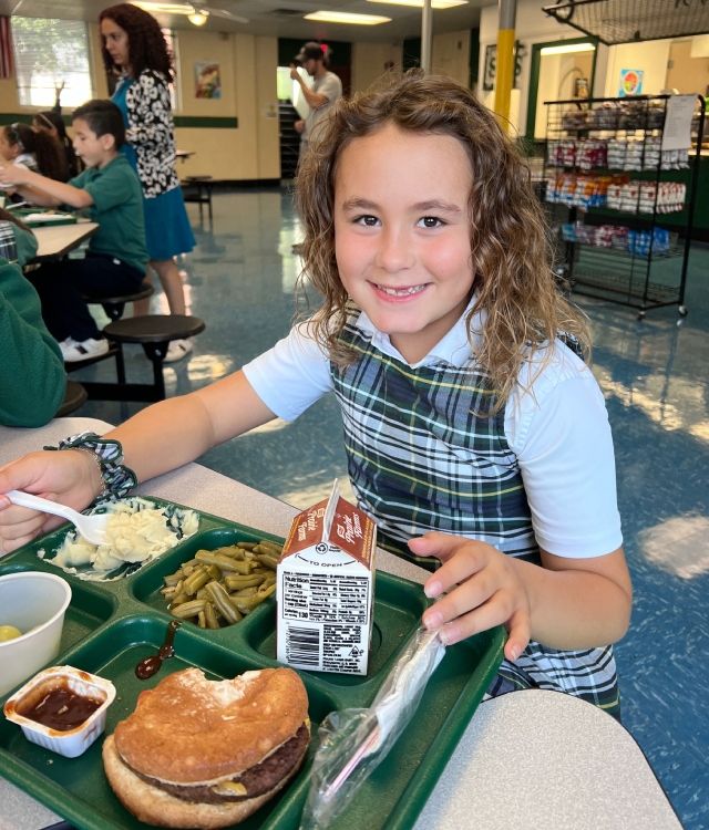 Student sitting at lunch table eating lunch