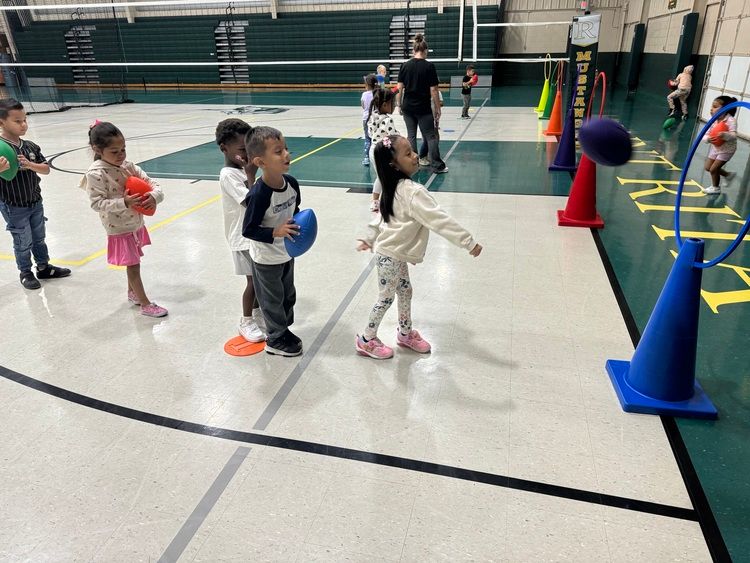 Class in the gym throwing footballs