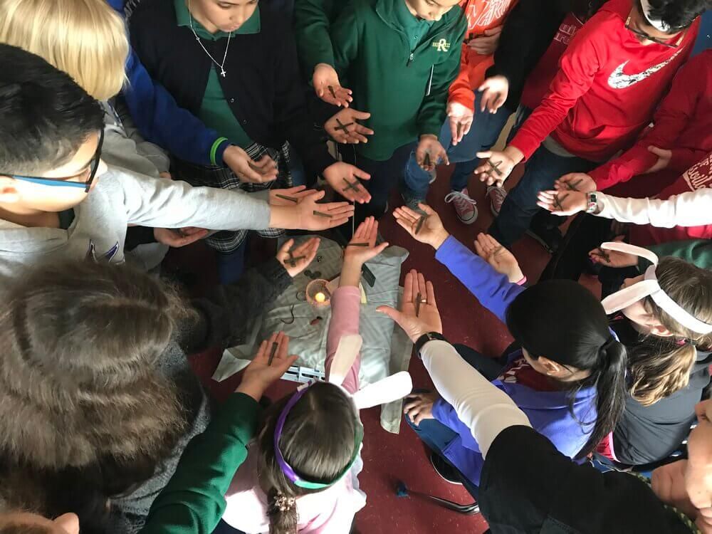 Students holding out their crosses in a circle
