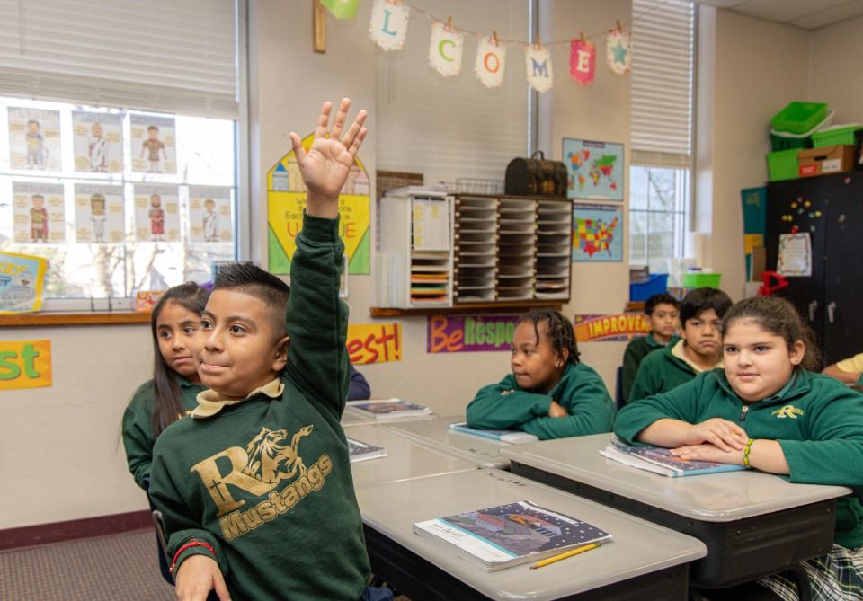 Three spanish language students looking at Dia de Muertos decorations