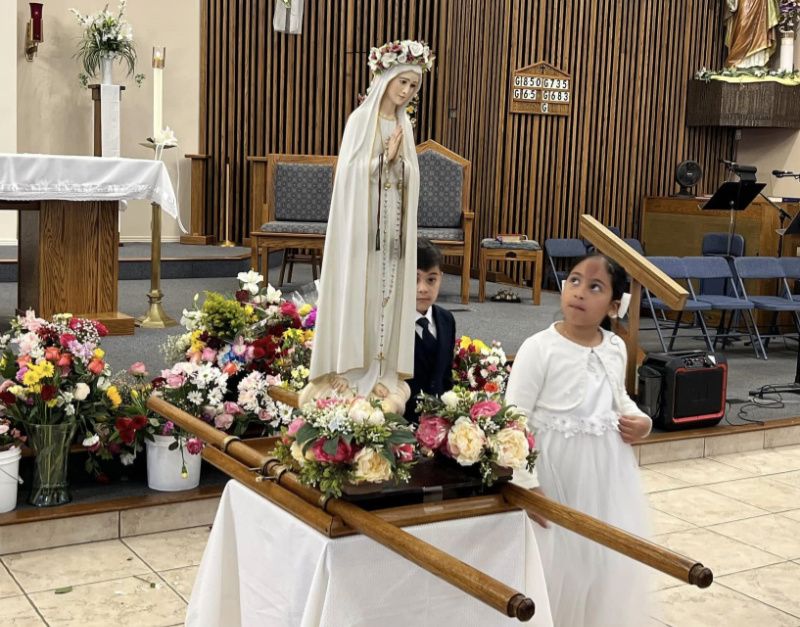 Student looking up at statue of Mary in the church