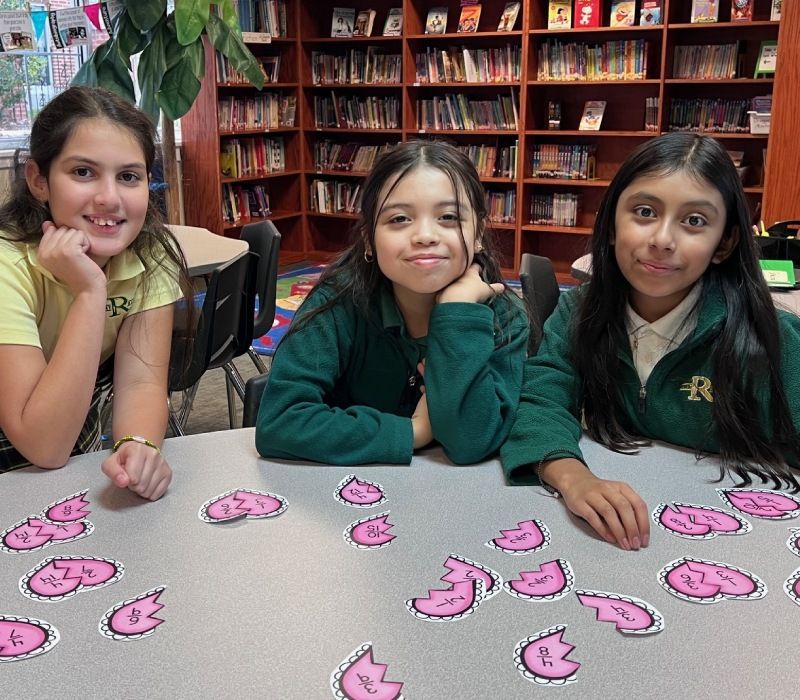 Teacher assisting students with paper worksheet